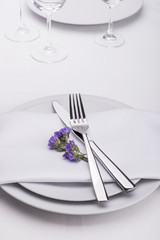 Restaurant table set with purple flowers