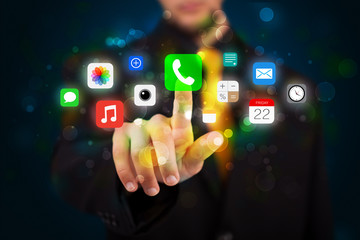 Handsome businessman pressing colorful mobile app icons with bok