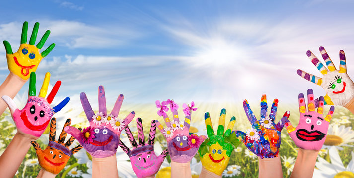 H&auml;nde spielender Kinder vor Blumenwiese