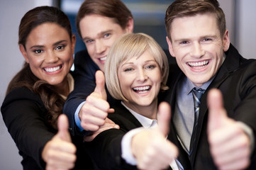 Corporate team gesturing thumbs up