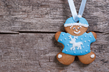 Gingerbread man in a blue cap and blouse, with deer