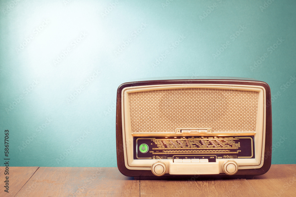 Wall mural Old retro radio with green eye light on table