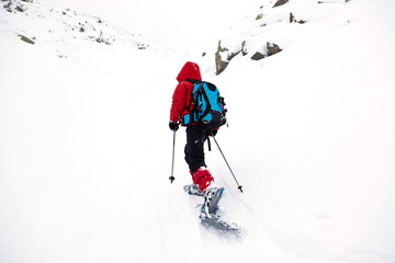 Fototapeta na wymiar Boy hikes in mountain with snowshoe