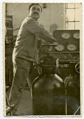 CIRCA 1955: In the factory, middle-aged man operated machines