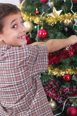 happy boy decorating the Christmas tree