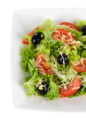 Light salad on plate isolated on white
