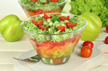 Tasty salad with fresh vegetables on wooden table