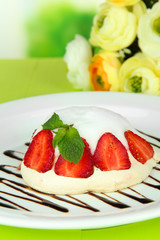 Tasty meringue cake with berries on green wooden table