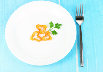Small portion of food on big plate on wooden table close-up