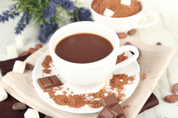 Cocoa powder in cup on napkin on wooden table