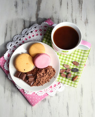 Cocoa in cup with sweets and cocoa powder