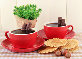 Red cups of strong coffee with chocolate bars and waffles
