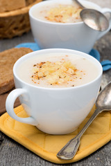 cream soup of cauliflower with cheese in a cups, vertical