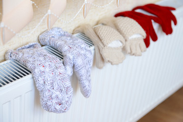 Knitted gloves drying on heating radiator