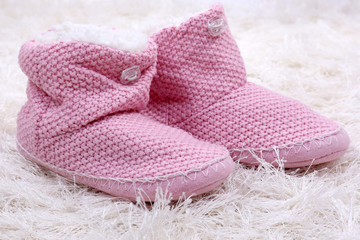 Warm winter home shoes on color background