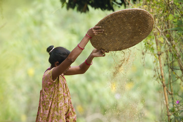 Nepali woman whisking rice in Terai