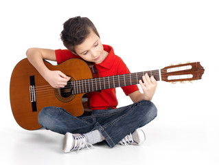 Fototapeta premium Smiling boy is playing the acoustic guitar
