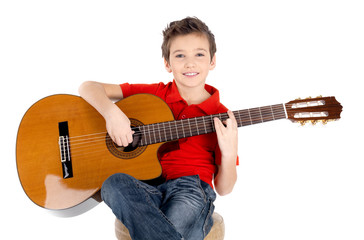 happy  boy is playing on acoustic guitar