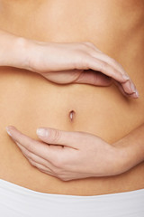 Close up on woman's hands touching hher belly.