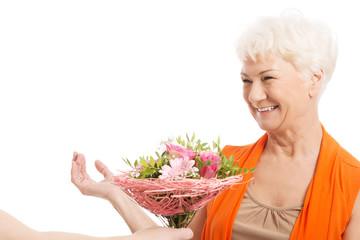 An old woman with bouquet of flowers.