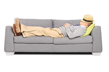 Mature man with hat over his head sleeping on a sofa