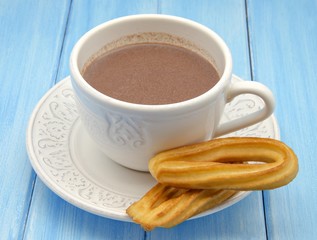 Taza con chocolate caliente y churros