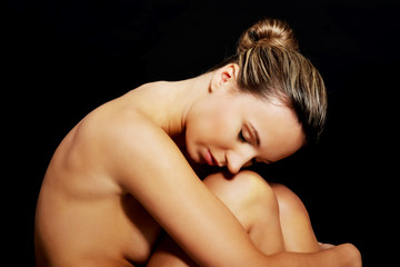 Nude woman sitting. Side view.