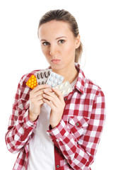 Young casual woman holding pills.