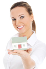 Young business woman holding a house on her palm.