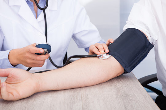 Doctor's Hand Checking Blood Pressure