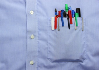 Blue shirt pocket with many different ballpoint pen and bottoms