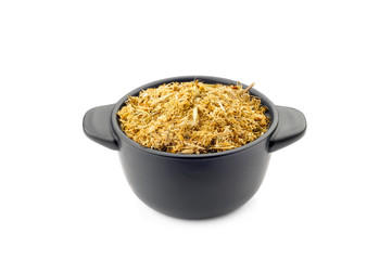Fragrant natural dry chamomile in a black ceramic dish