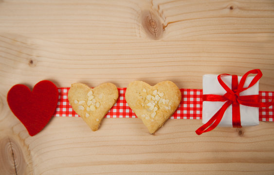 Valentinskarte mit Herzplätzchen auf hölzernem Hintergrund