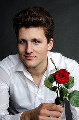 Junger Mann mit roter Rose