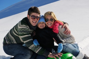 family having fun on fresh snow at winter vacation