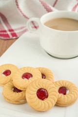 Strawberry jam sandwich biscuits with coffee cup