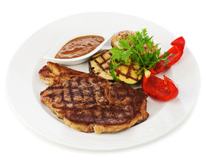 Grilled steaks, baked potatoes and vegetables on white plate.