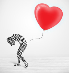 Fototapeta premium Cute guy in morpsuit body suit looking at a balloon shaped heart