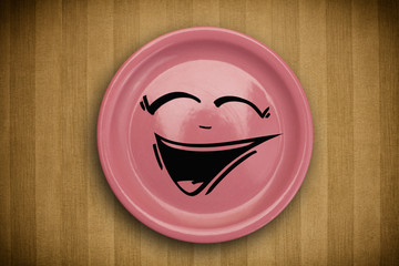 Happy smiley cartoon face on colorful dish plate