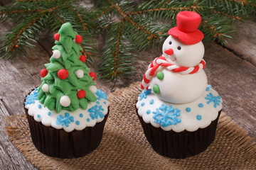 Two Christmas cupcake: Christmas tree and snowman on the table