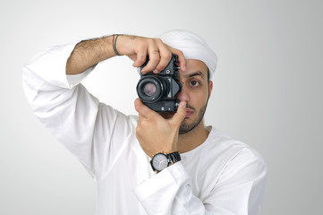 Young Arabian man using holding his camera isolated