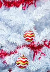Fototapeta na wymiar Christmas red balls and decorations on white Christmas tree