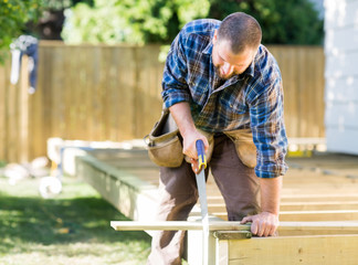 Worker Sawing Wood At Construction Site