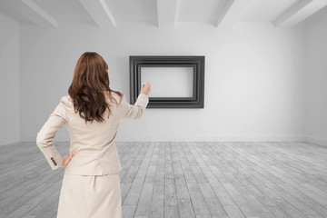 Composite image of businesswoman standing back to camera writing