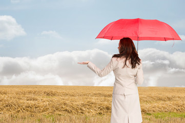 Composite image of businesswoman holding umbrella