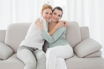 Fototapeta na wymiar Cheerful young female friends embracing in living room