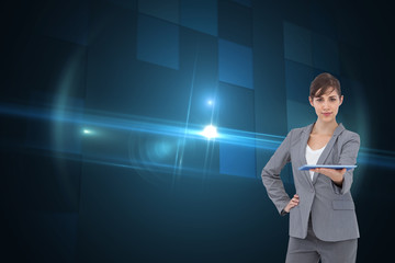 Composite image of attractive businesswoman holding tablet pc