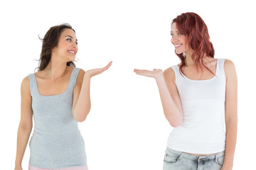 Two happy young female friends holding out their hands