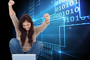 Composite image of brunette cheering while using laptop