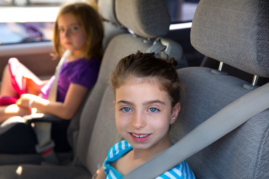 Kid girls with safety belt in car indoor